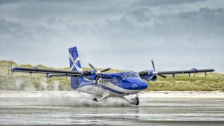 A Twin Otter aircraft, operated by Loganair, departing Barra airport on Traigh Mhor beach