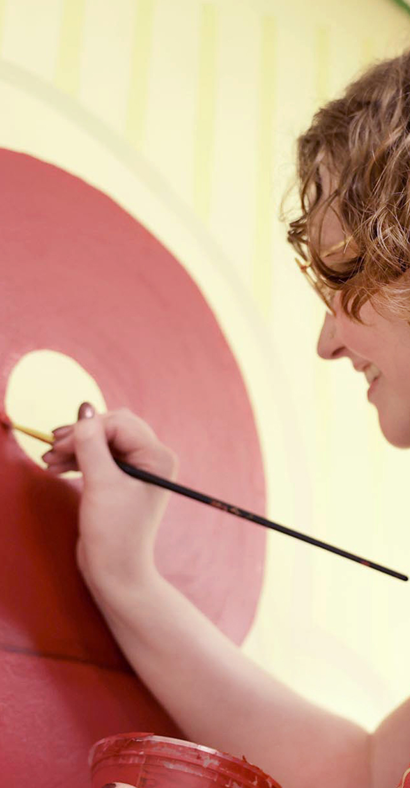 Design students painting the walls of a room with Cyclone colors and phrases.