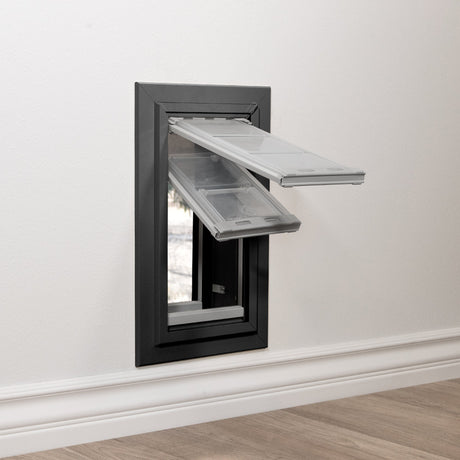 Endura Flap Pet Door for Thick Walls in double flap with the dual pane clear flap swung outward at nearly 90 degrees from a dark bronze frame, the through-wall tunnel depth visible inside.