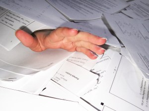 Hand reaching through paperwork