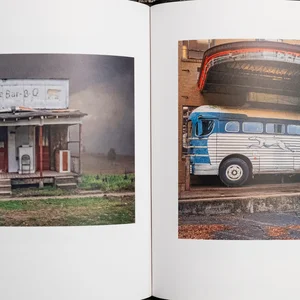 Le livre photo carré de Clay Fisher, « SlowExposures 2023 », s'ouvre sur une photo d'une cahute située sur le bord d'une route et d'un vieux car.