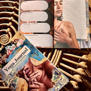 Diario de yoga en color abierto por una página de meditación sobre una mesa de mimbre.