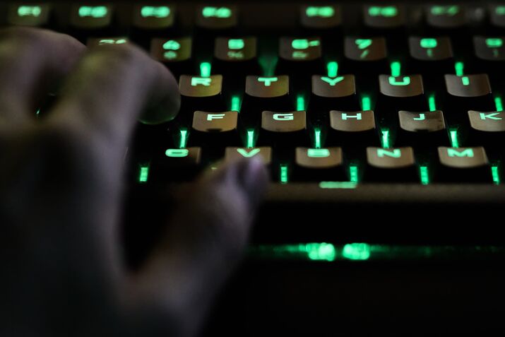 Man's hand using rgb keyboard while live streaming