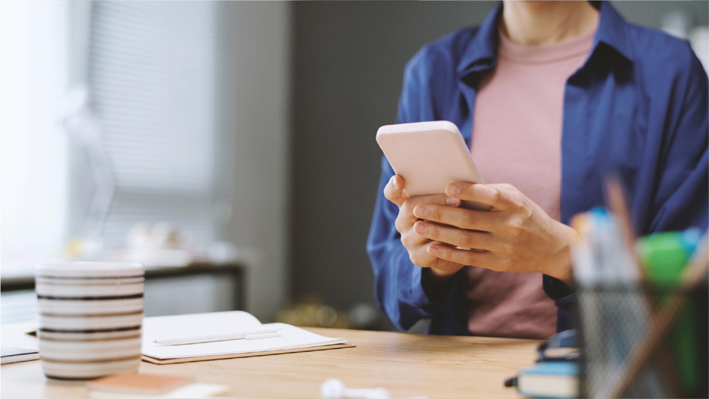 Woman looking at phone receiving an automated payment reminder. Now the practice doesn't have to worry about healthcare collections.