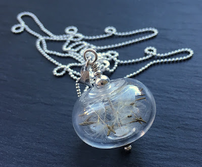 Lampwork glass bead and sterling silver necklace filled with dandelion clock seeds Lampwork glass bead and sterling silver necklace filled with dandelion clock seeds