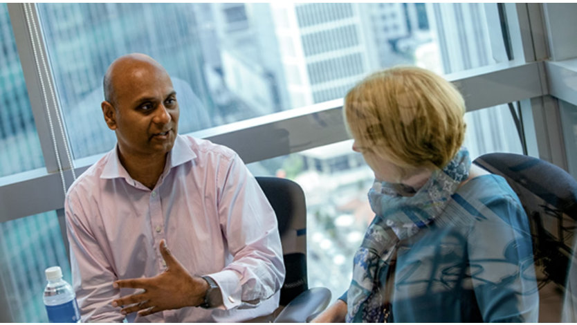 Two coworkers talking while sitting in an office building