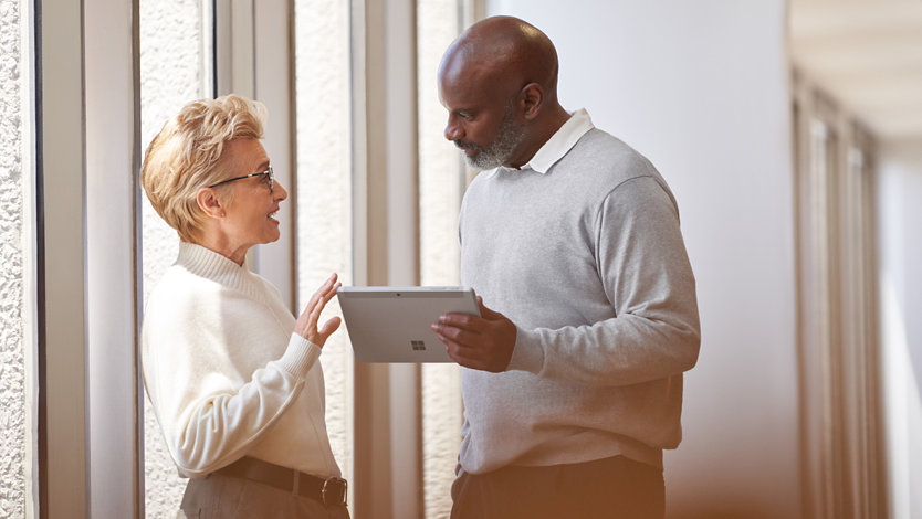 Business colleagues having a discussion over a tablet device.