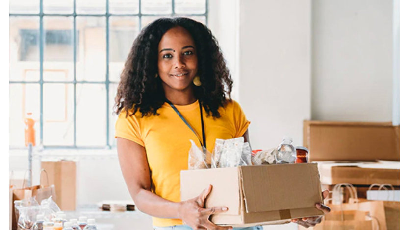 Volunteer holding a box of food and drinks