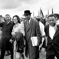 Martin Luther King Jr., and his wife, Coretta, lead off the final lap to the state capitol at Montgomery, Alabama on March 25, 1965. Thousands of civil rights marchers joined in the walk, which began in Selma, demanding voter registration rights