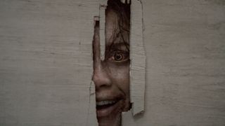 Deadite Thya's face peering through hole in a wall Shining-style in Evil Dead Burn