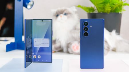 Two blue Samsung Galaxy Z Fold 7 devices with a stuffed cat behind them
