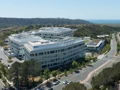 Aerial view of a large Pfizer office complex surrounded by trees and winding roads