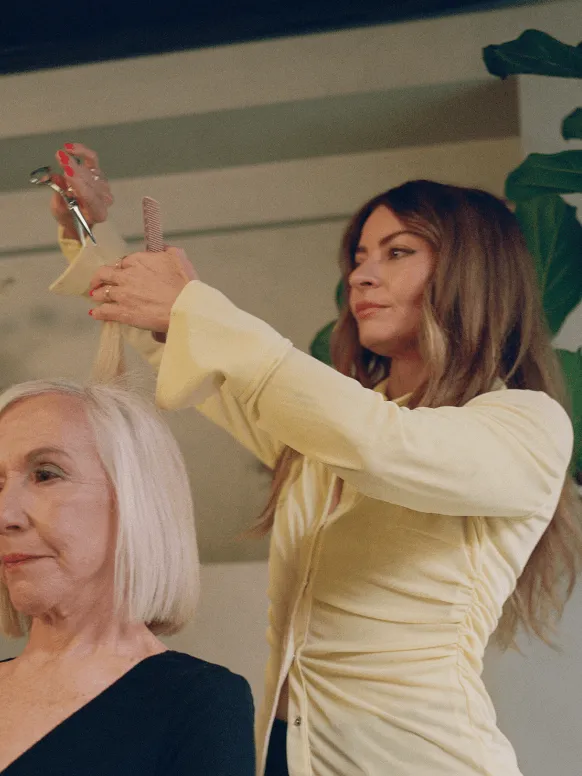 Image of a female hairstylist cutting a female client’s short blonde bob