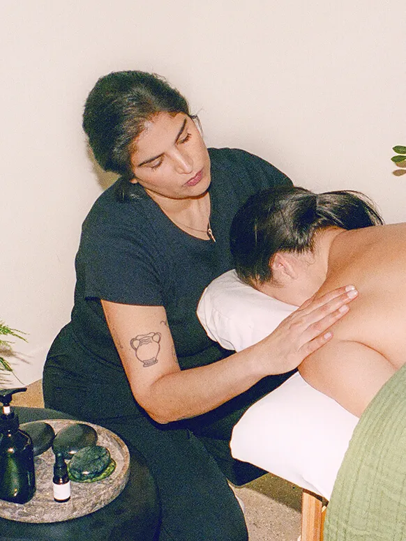 A masseuse giving her client a shoulder massage