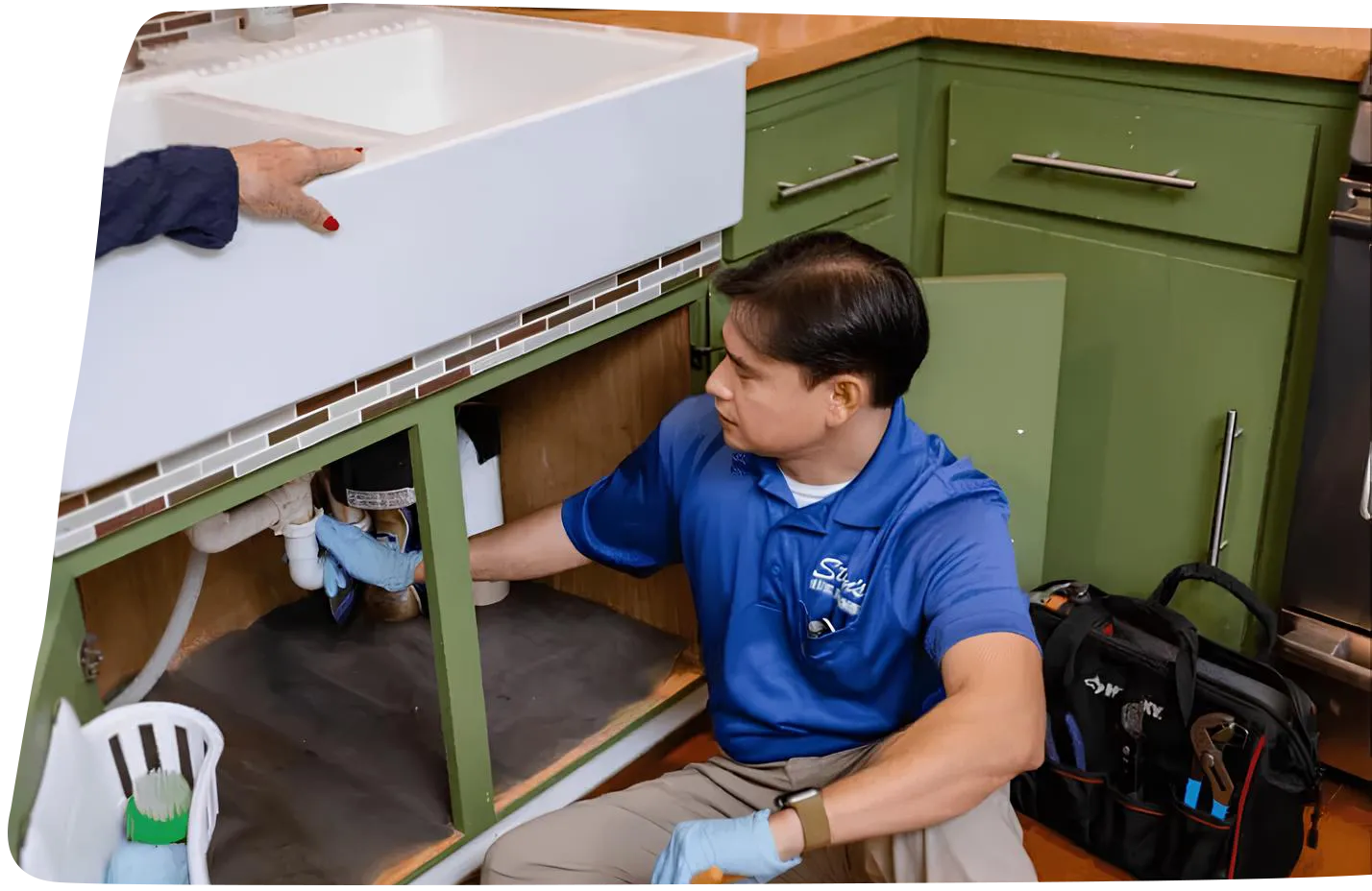 Plumber fixing sink in kitchen