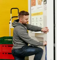 a man in a gray hoodie leaning against a foodji