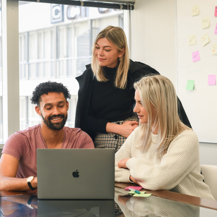 Team of three sitting at laptop