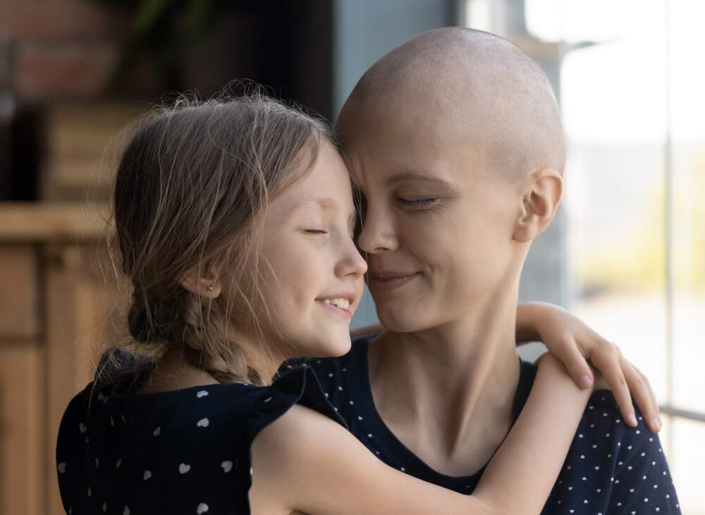 cancer patient smiling while hugging child