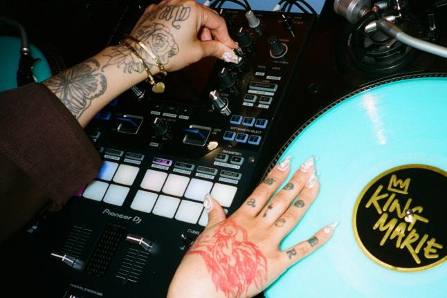 DJ King Marie’s hands on a DJ controller, performing live with Serato professional DJ software.