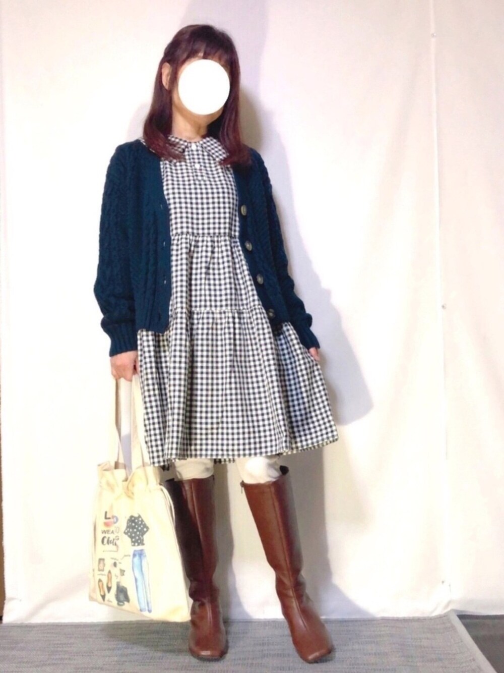 ブラック系のワンピース、ブルー系のカーディガン/ボレロ、ブラウン系のブーツを着用したレディースの春コーディネートの1枚目の写真