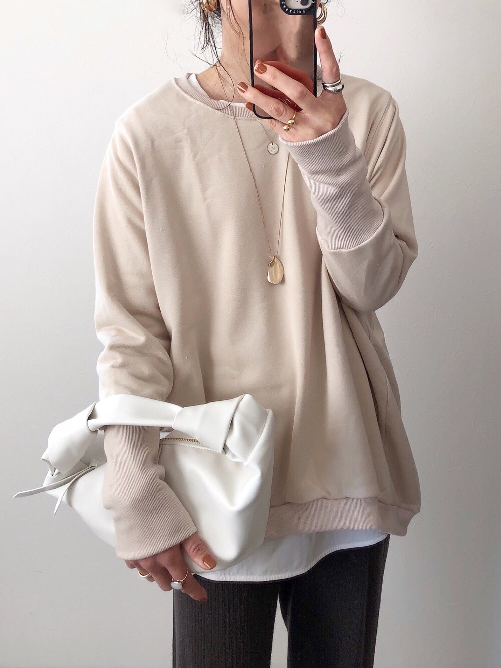 ベージュ系のスウェット、ホワイト系のTシャツ/カットソーを着用したレディースの冬コーディネートの1枚目の写真