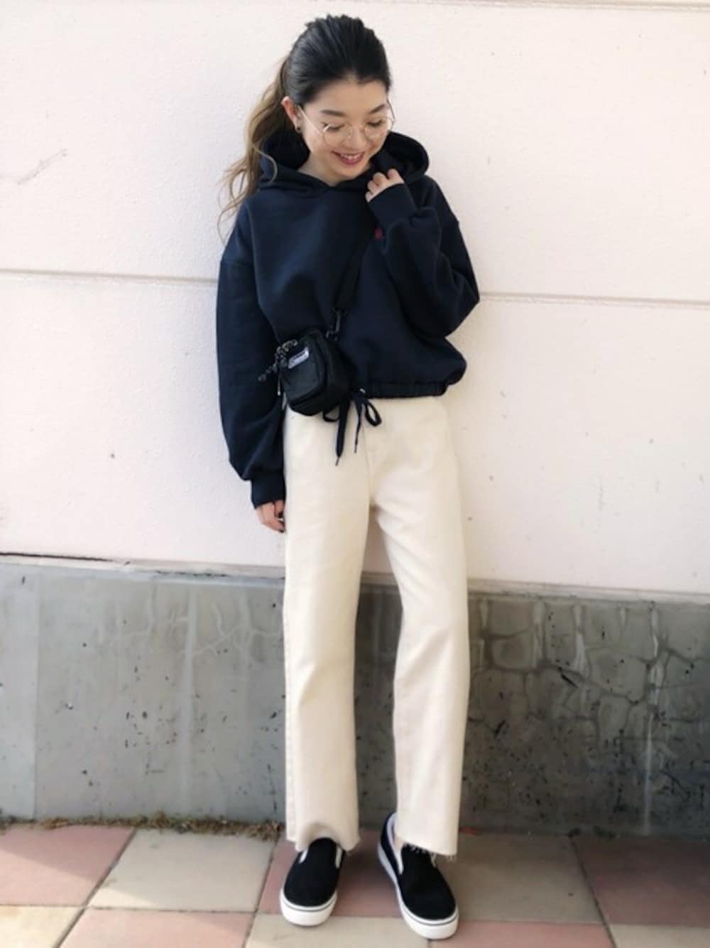 ブルー系のパーカー、ベージュ系のチノパンツ、ブラック系のスリッポンを着用したレディースの冬コーディネートの1枚目の写真