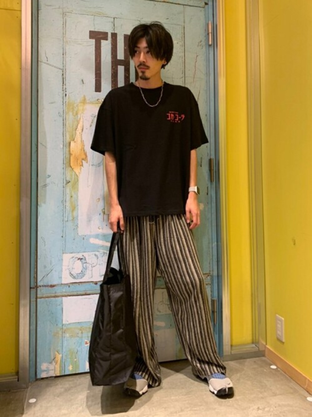 ブラック系のトートバッグ、ブラック系のTシャツ/カットソーを着用したメンズの夏コーディネートの1枚目の写真