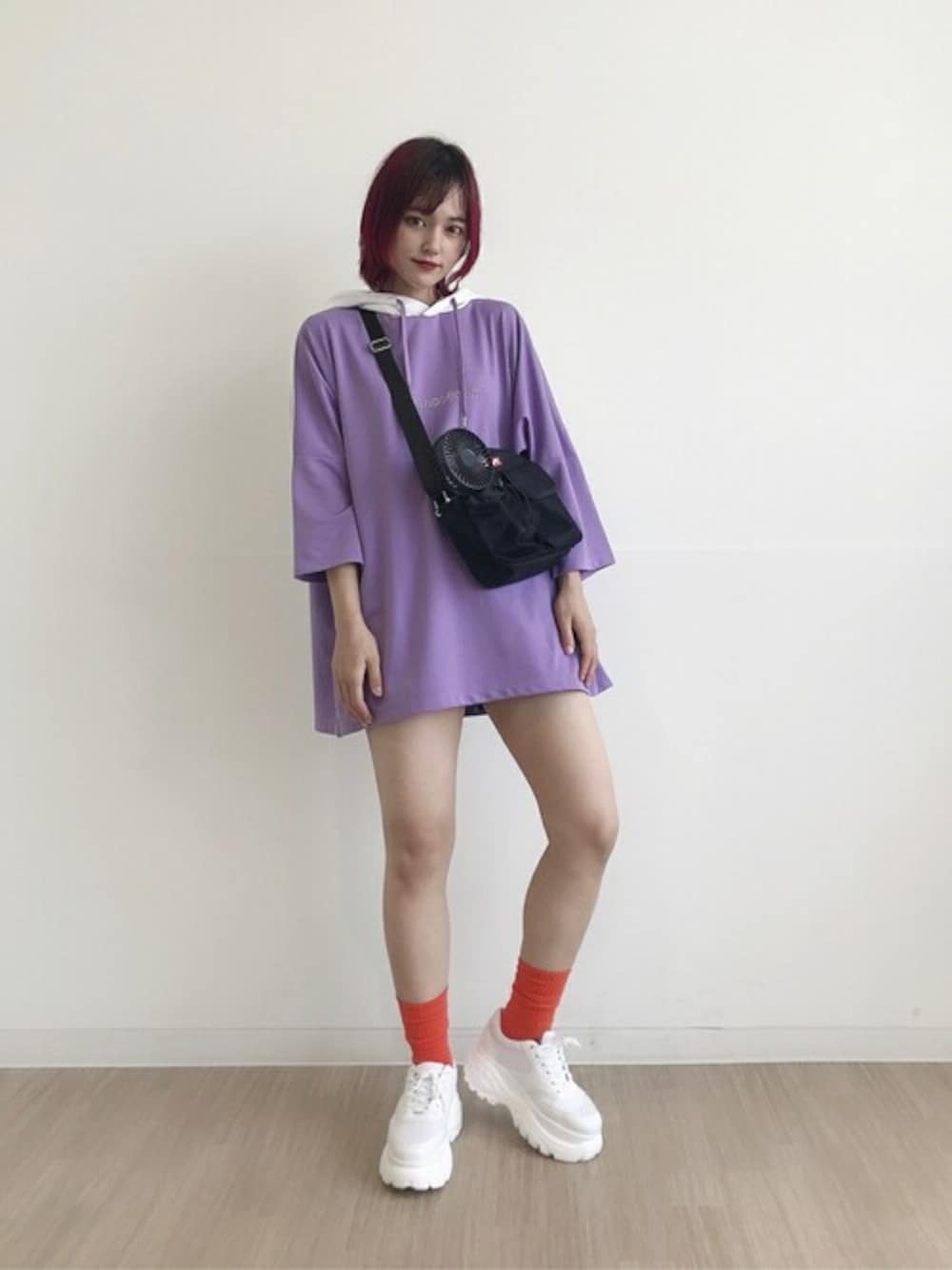 パープル系のパーカー、ブルー系のデニムパンツ、ホワイト系のスニーカーを着用したレディースの夏コーディネートの1枚目の写真