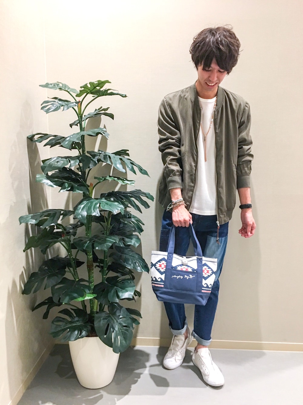 グリーン系のブルゾン、ブルー系のデニムパンツ、ブルー系のトートバッグを着用したメンズの春コーディネートの1枚目の写真
