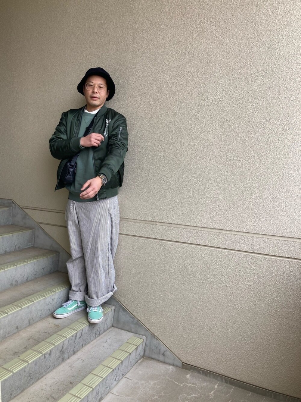 グリーン系のブルゾン、グレー系のその他パンツ、グリーン系のスニーカーを着用したメンズの春コーディネートの1枚目の写真