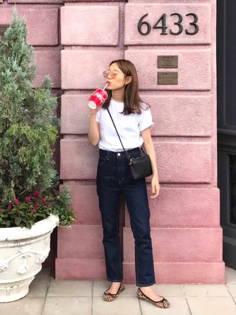 ホワイト系のTシャツ/カットソー、ブルー系のデニムパンツ、ブラック系のショルダーバッグを着用したレディースの秋コーディネートの1枚目の写真
