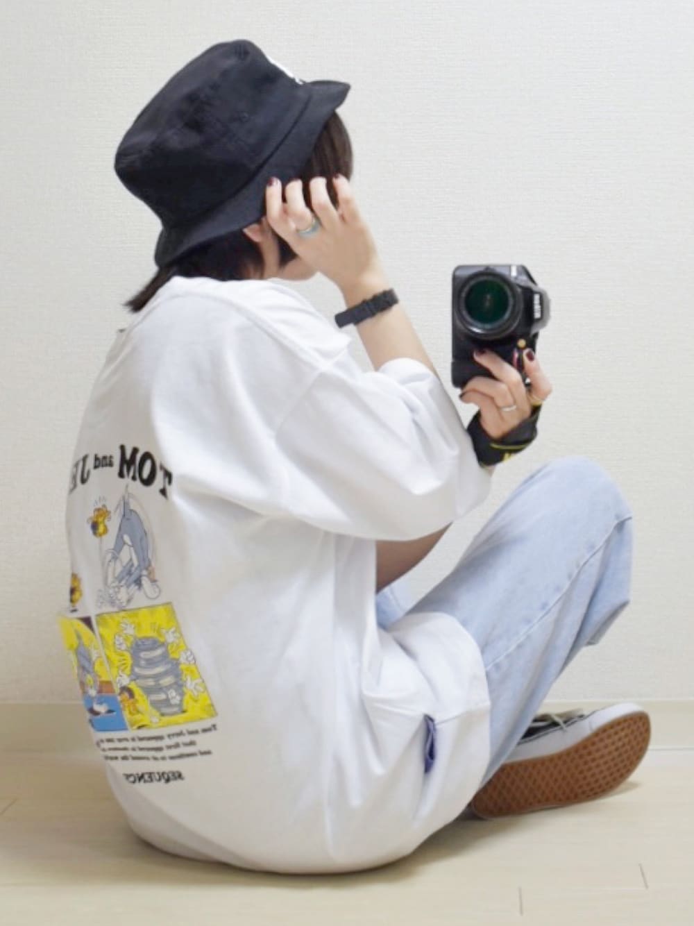 ホワイト系のTシャツ/カットソー、ブルー系のデニムパンツ、ブラック系のスニーカーを着用したレディースの春コーディネートの1枚目の写真