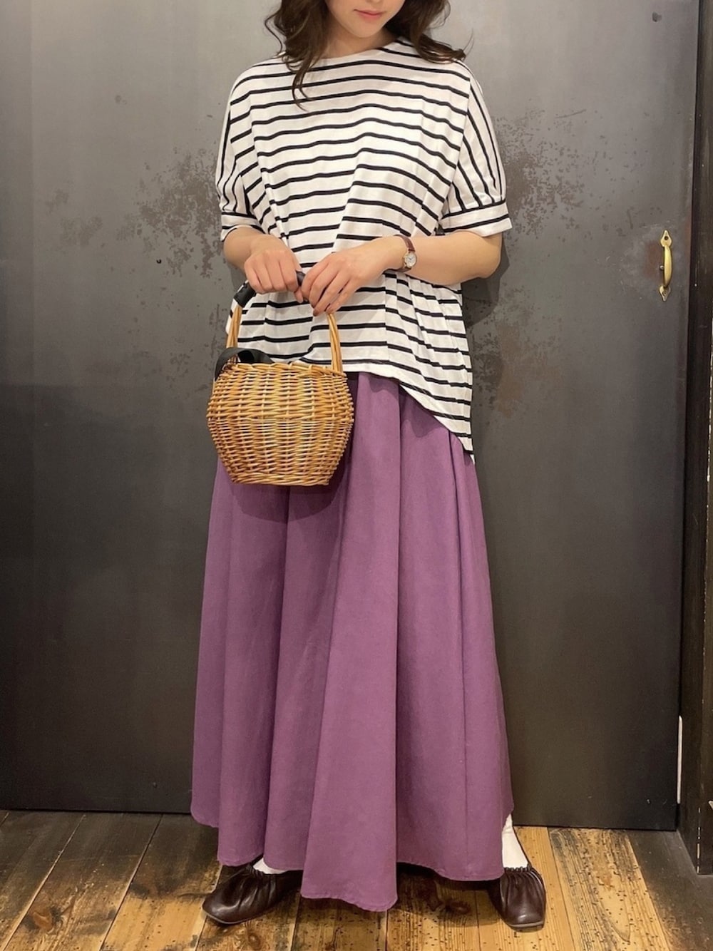 パープル系のスカート、ホワイト系のTシャツ/カットソーを着用したレディースの春コーディネートの1枚目の写真