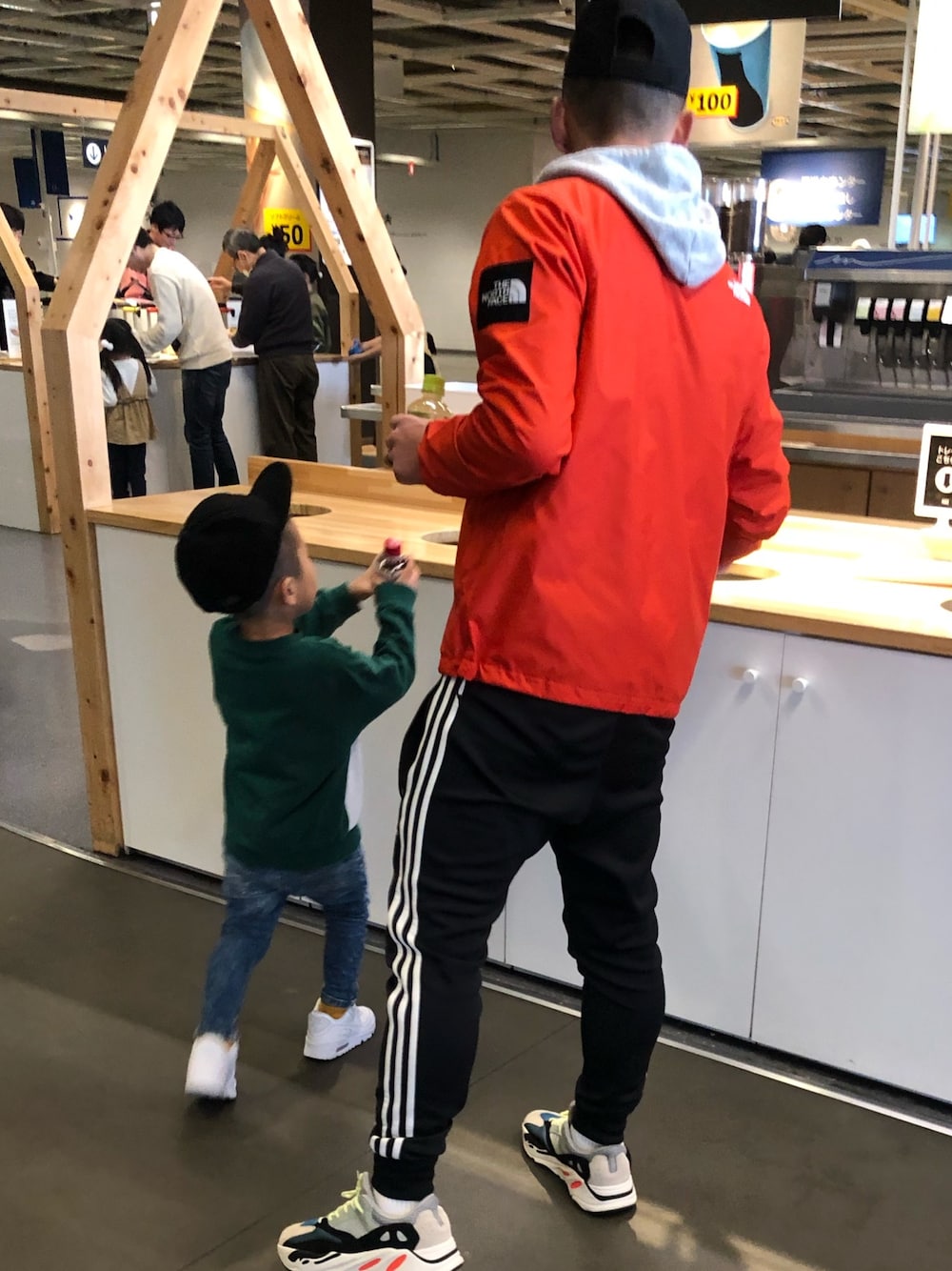 ホワイト系のスニーカー、レッド系のナイロンジャケット、ブラック系のその他パンツを着用したキッズの冬コーディネートの1枚目の写真