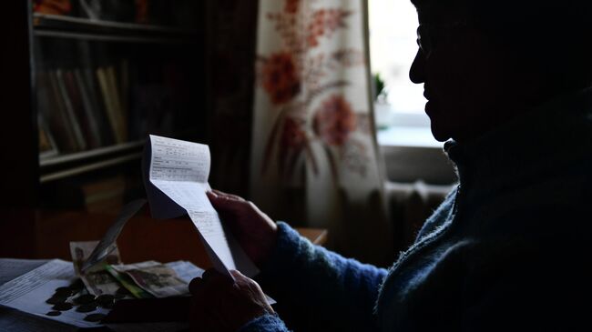 Женщина держит в руках квитанцию ЖКХ Женщина держит в руках квитанцию ЖКХ