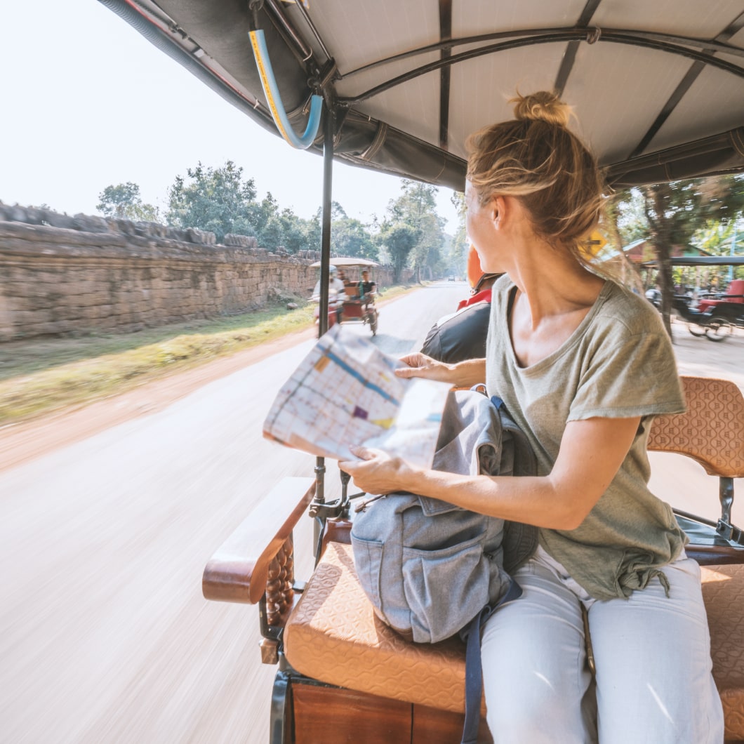 Una viajera con un mapa en el asiento de atrás de un rickshaw