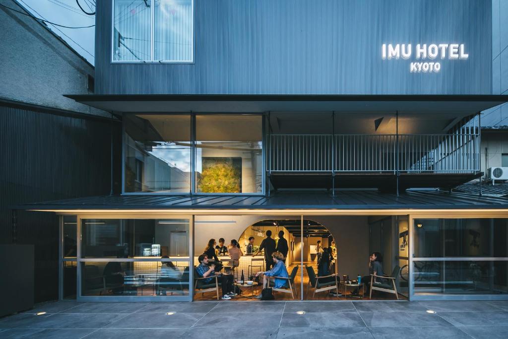 een groep mensen die buiten een gebouw zitten bij Imu Hotel Kyoto in Kyoto