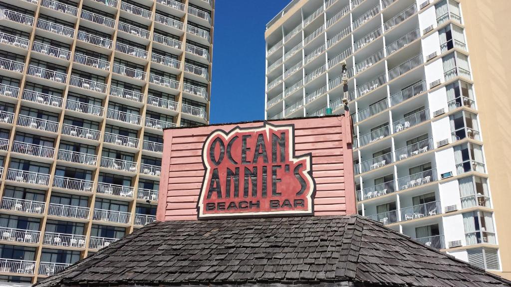 ein rosafarbenes Gebäude mit einem Schild darüber in der Unterkunft Ocean Annie's Resorts in Myrtle Beach