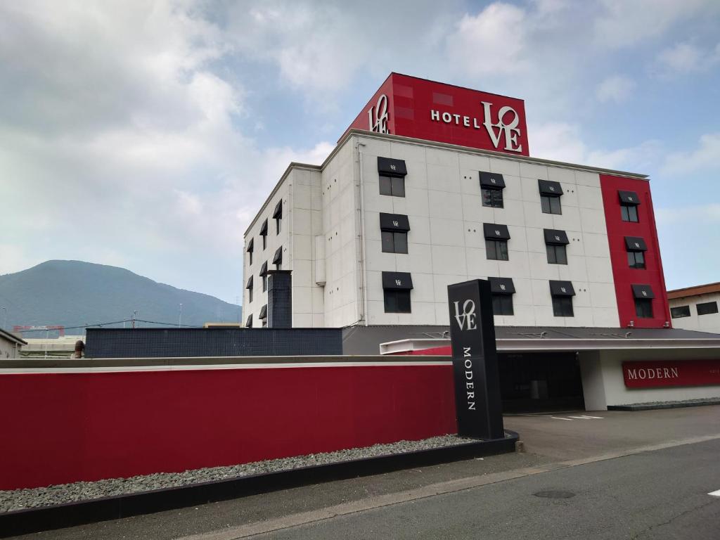 ein Hotelgebäude mit einem Schild davor in der Unterkunft Hotel LOVE MODERN in Kitakyūshū