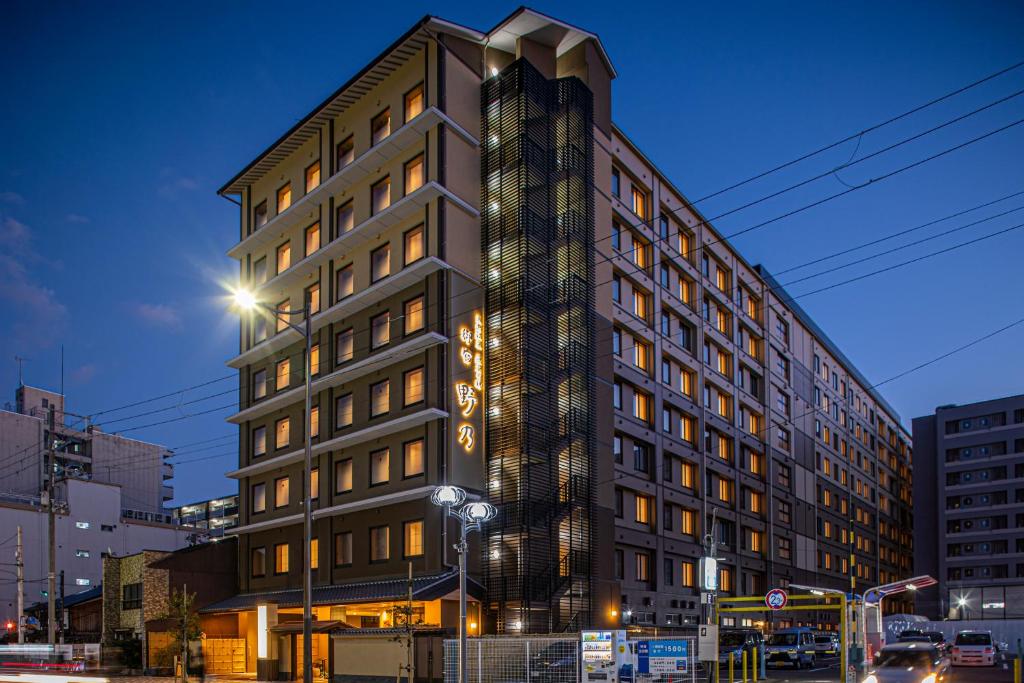 a tall building is lit up at night at Onyado Nono Kyoto Shichijo Natural Hot Spring in Kyoto