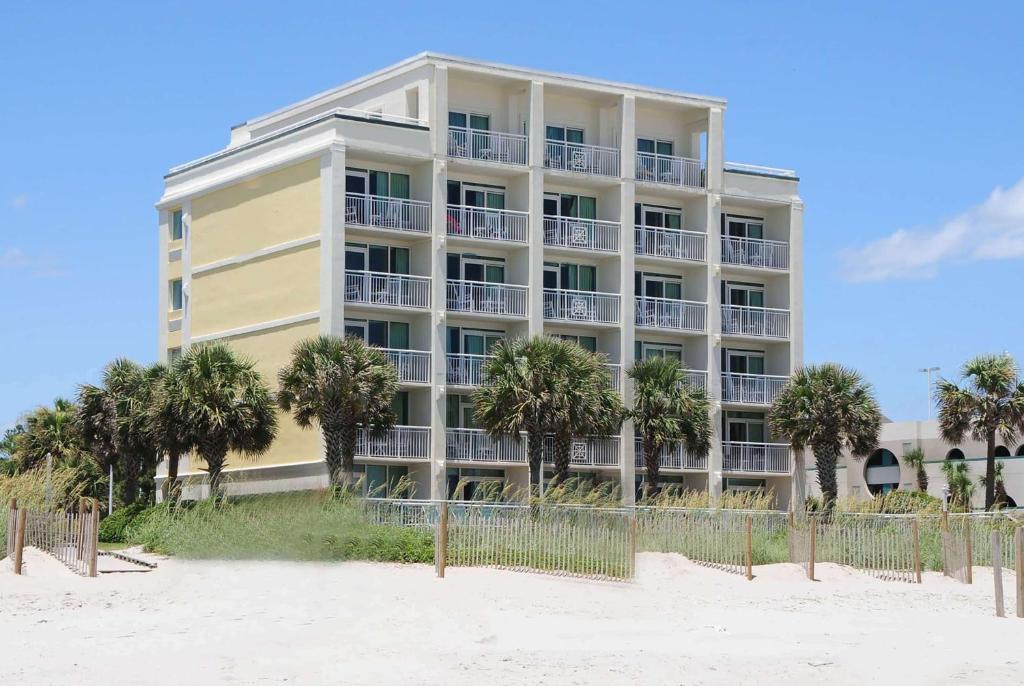 ein Gebäude am Strand mit Palmen davor in der Unterkunft The Sandbar Hotel, Trademark Collection by Wyndham in Myrtle Beach