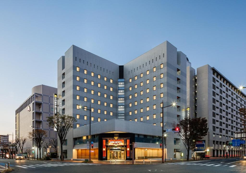 ein großes Gebäude in der Nacht auf einer Stadtstraße in der Unterkunft APA Hotel Kokura Ekimae in Kitakyūshū