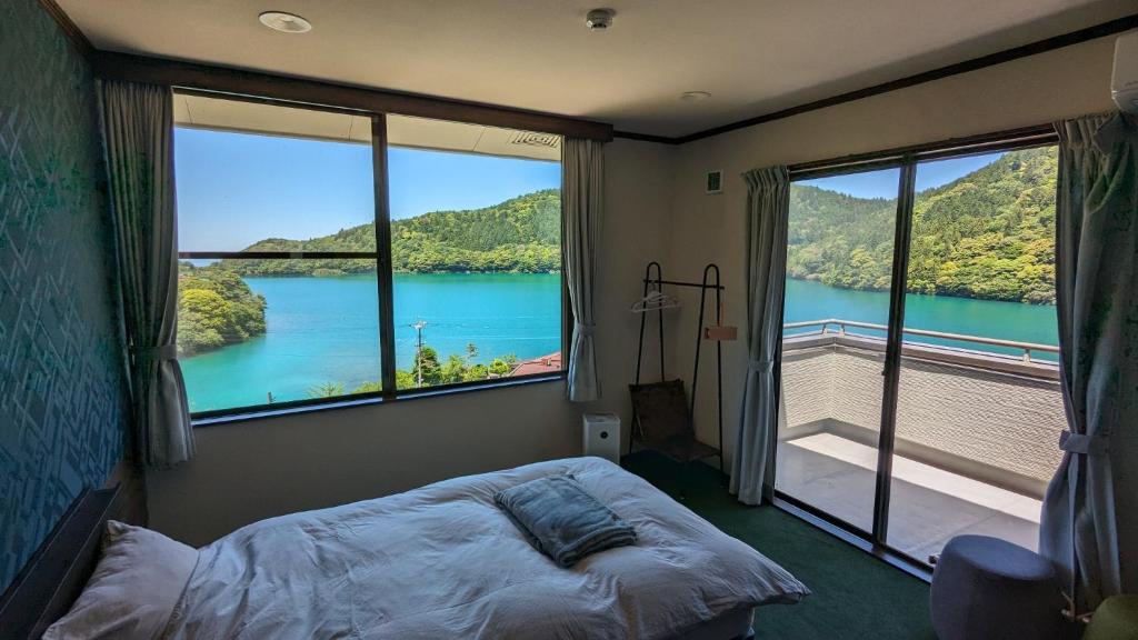 een slaapkamer met een groot raam met uitzicht op het water bij H,U,B Unzen - Vacation STAY 01672v in Unzen