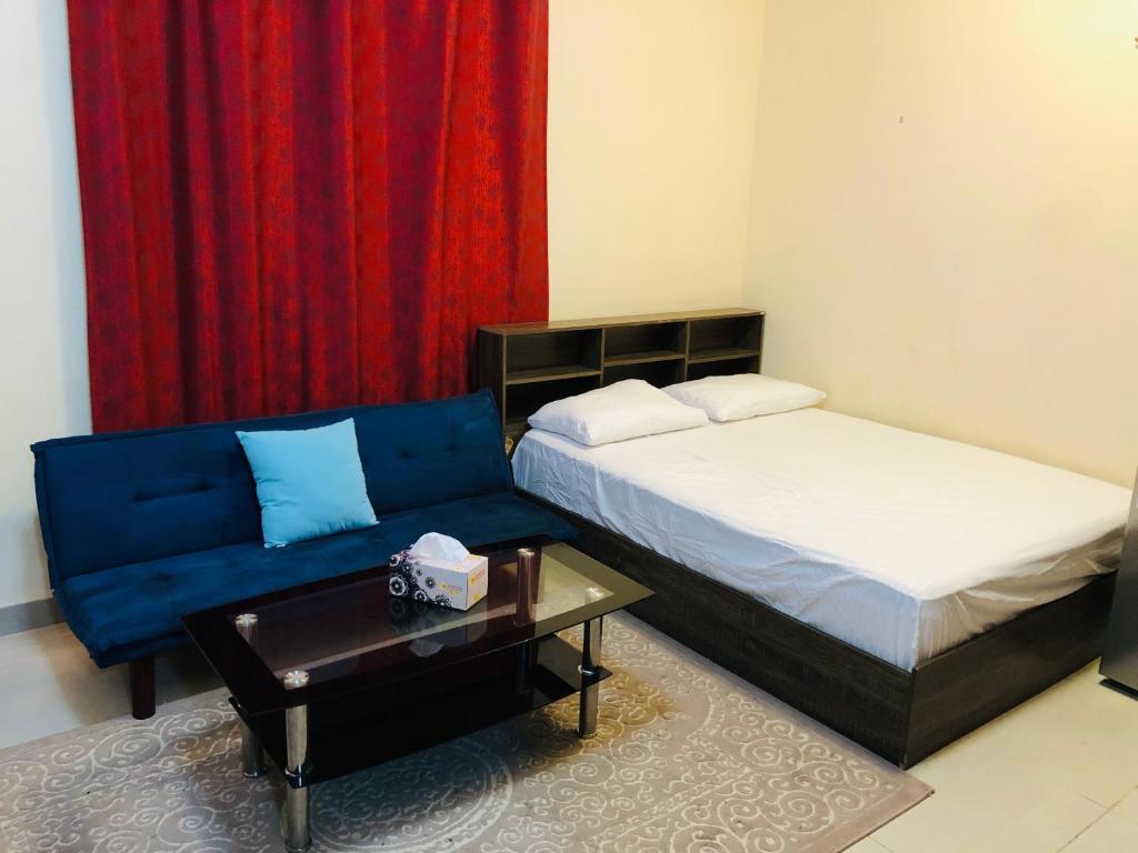 a bedroom with a bed and a couch and a table at Premium Furnished studio in Sharjah