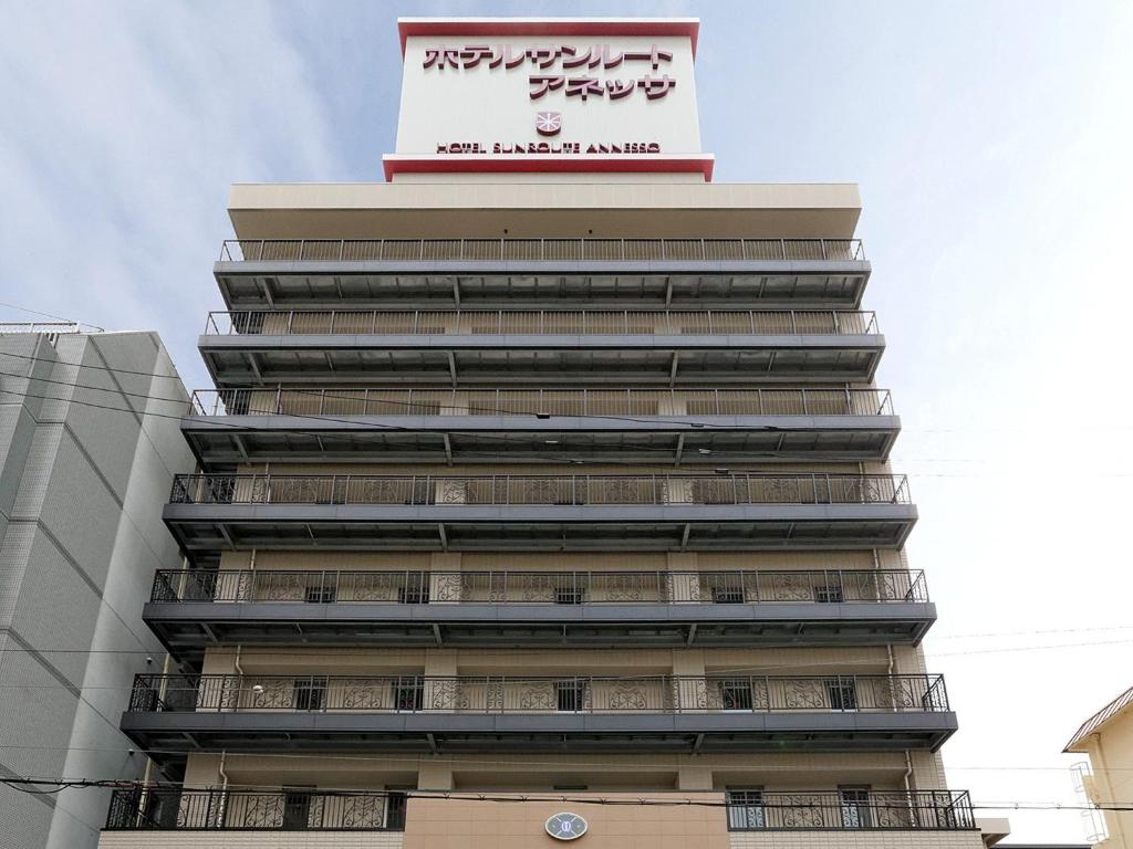 Un palazzo alto con un cartello sopra. di Hotel Sunroute Sopra Kobe Annesso a Kobe