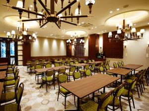 une salle à manger avec des tables et des chaises ainsi qu'un lustre dans l'établissement S.Training Center Hotel Osaka, à Osaka