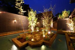 a garden with lights in a backyard at night at Yunoyado Irifune in Aso