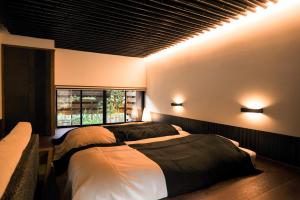 a bedroom with two beds and lights on the wall at Yunoyado Irifune in Aso