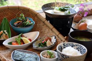 a table with bowls and plates of food on it at Yunoyado Irifune in Aso