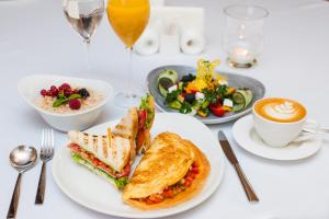 a table with a white plate with a sandwich and a salad at The ONE Hotel Astana in Astana